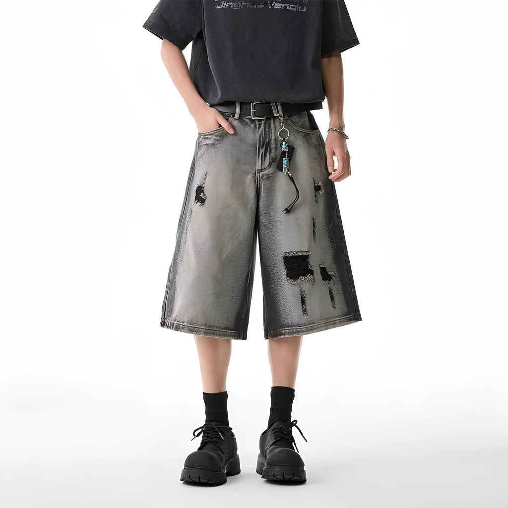 Grey women's denim shorts with water washed finish and hole distressing, loose cropped fit