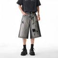Grey women's denim shorts with water washed finish and hole distressing, loose cropped fit