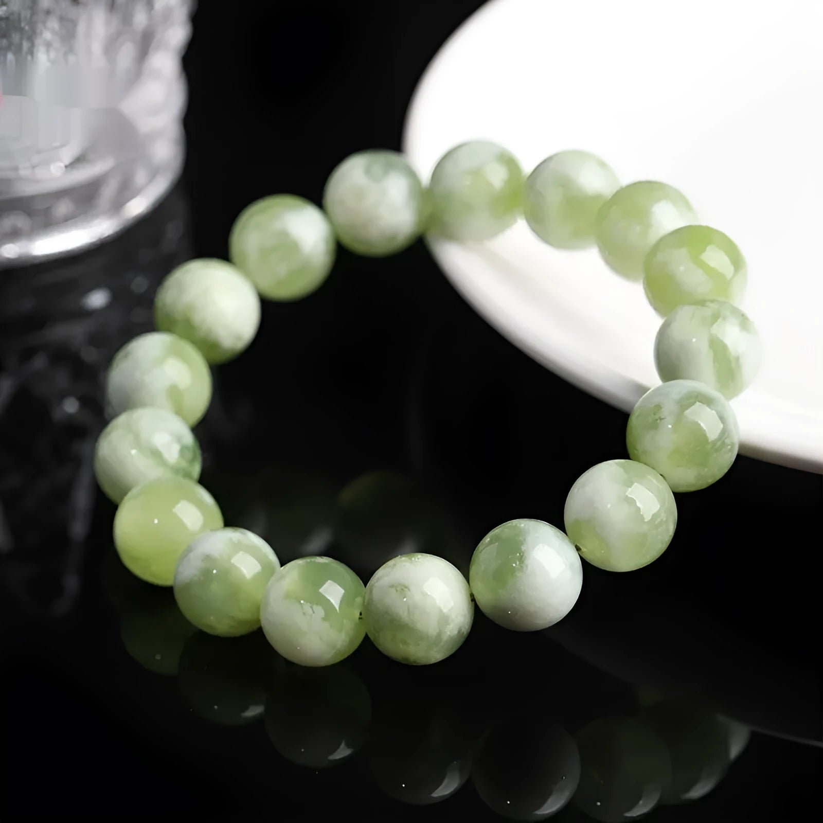 Green milk-in-water Xiuyan jade bracelet with polished geometric beads on a wrist.