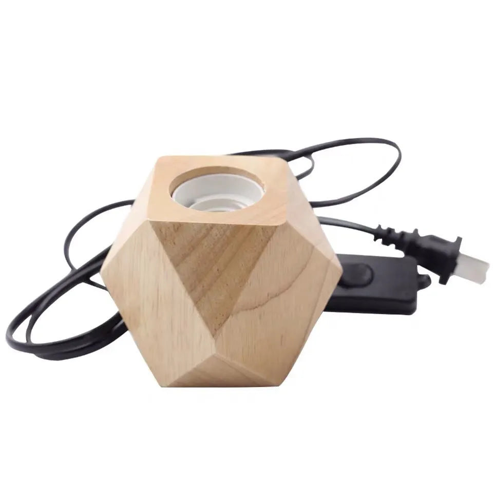 Retro-style square wooden lamp holder on a table next to a power cord.