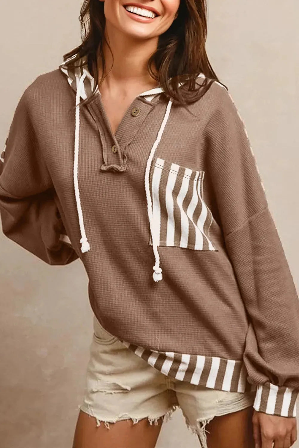 Straw yellow hoodie with waffle texture, striped patchwork, a button neck, and a drawstring hood.