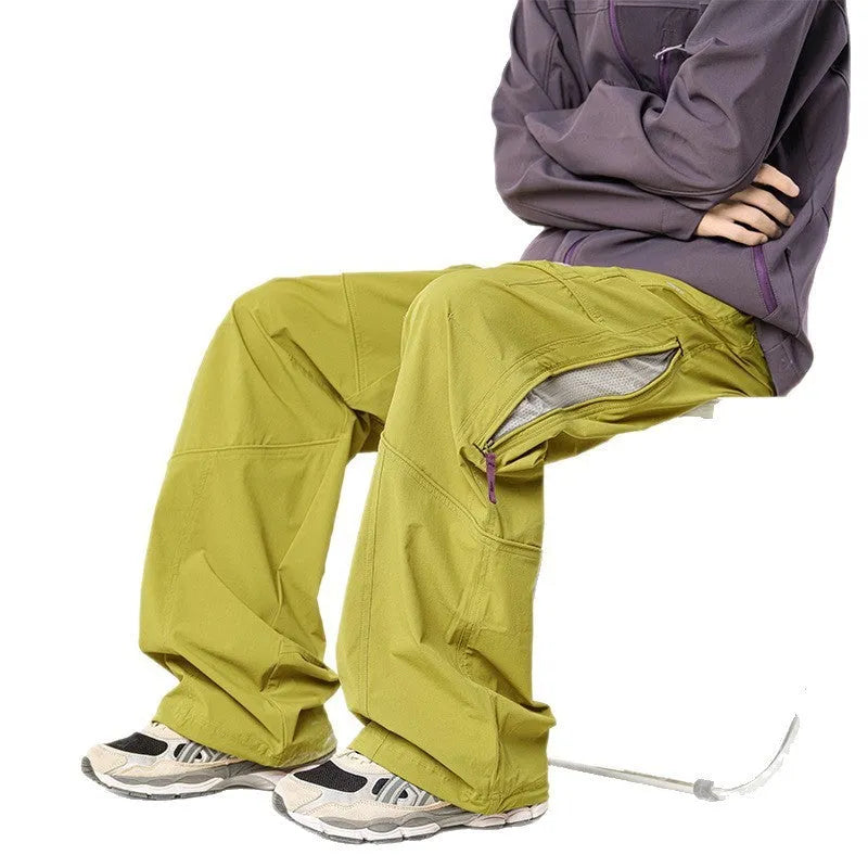 Men's waterproof loose casual pants in Graphite Black for outdoor use, side view on mountain trail