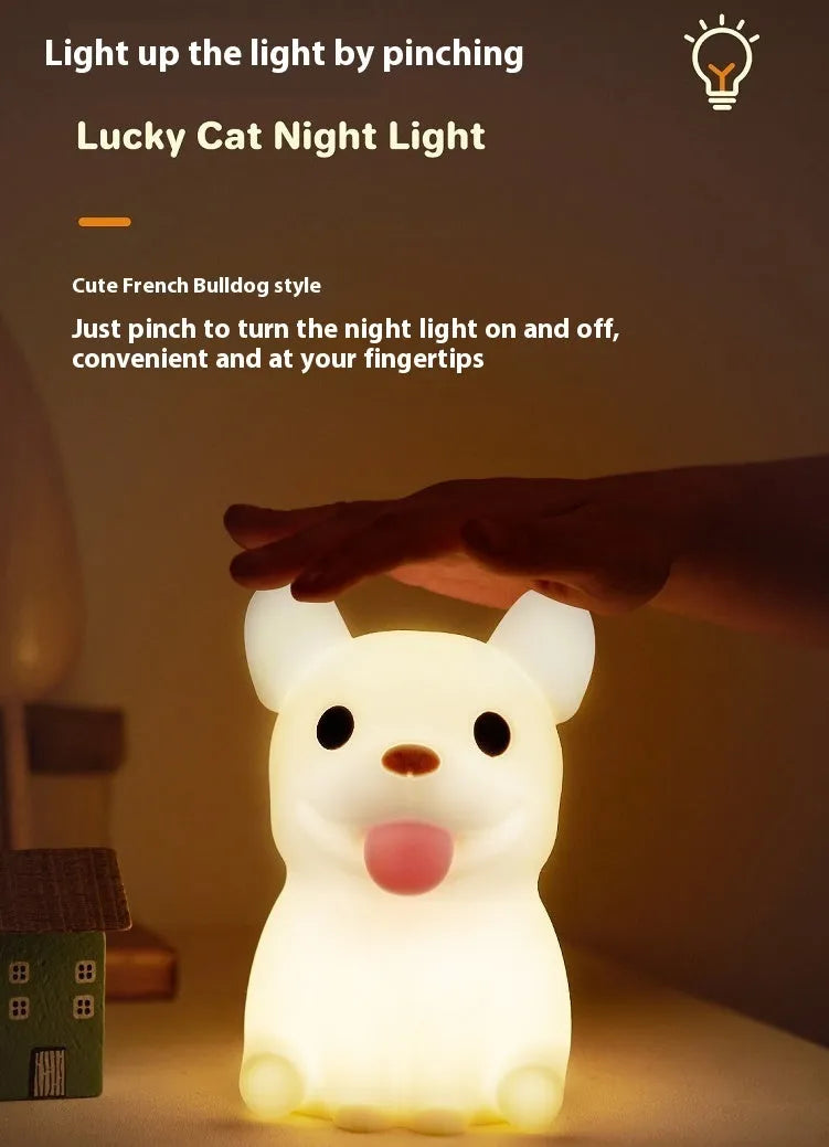 A cartoon bull-shaped silicone USB night light with a dimming function on a bedside table.