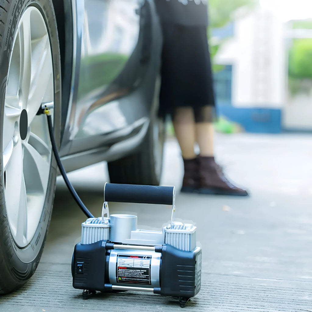 High power metal double cylinder 12V car air pump with battery clips and nozzle kit on black background