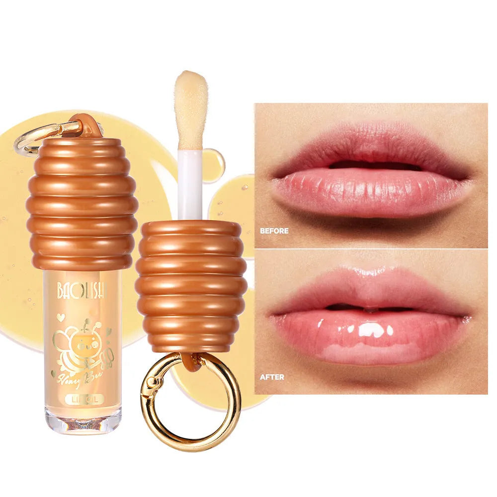 Honey lip gloss attached to a keychain next to a small reusable fabric pannier bag.