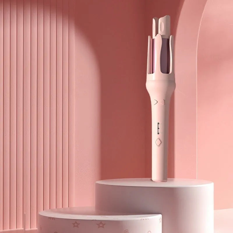 White and pink automatic hair curler with a 32mm rotating ceramic barrel and clamp, resting on a table with international power adapters.