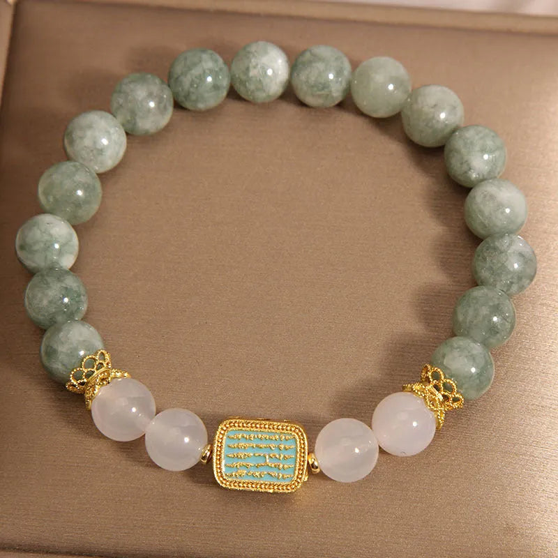 Close-up of a women's oil green emerald crystal bracelet featuring a five-piece sutra design.