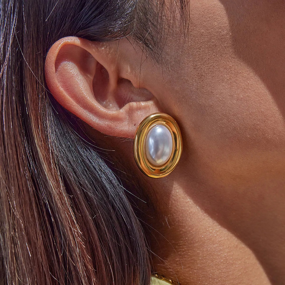 A pair of stainless steel vintage pearl stud earrings for women with a silver-toned finish and a fixed white pearl.