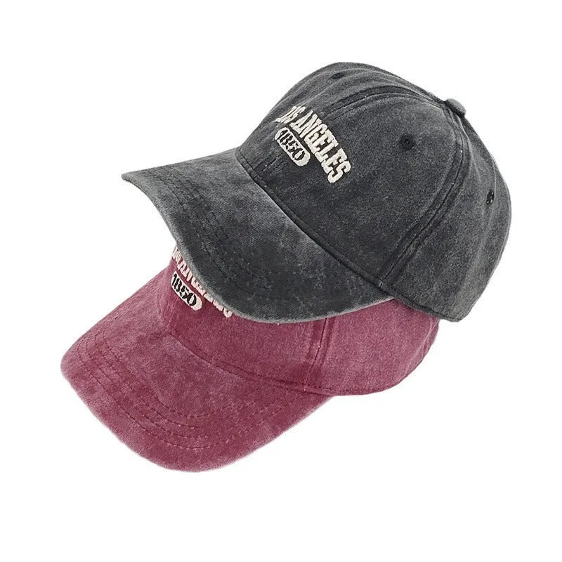 Distressed beige baseball cap with embroidered letters on the front, showing adjustable strap and curved 7cm peak.