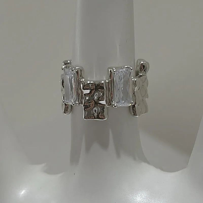 Silver cross ring with geometric design and open gemstone setting