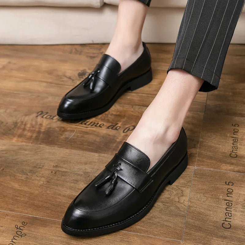 Men's black slip-on loafers with a tassel decoration on a pointed-toe, low-top artificial PU upper.