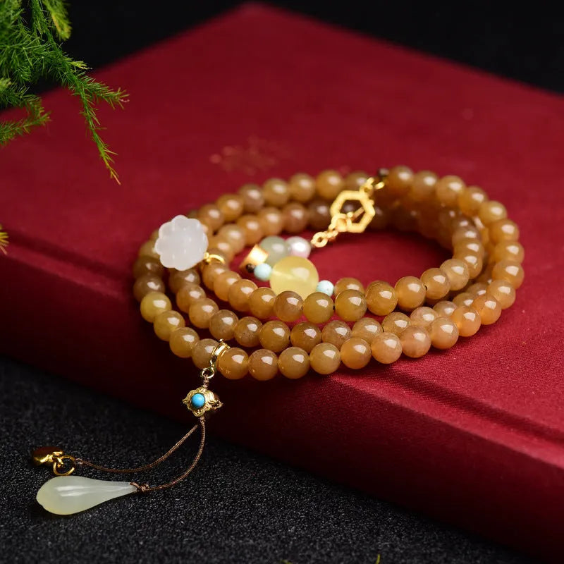 Green pine jade bracelet with 6mm round beads, leaf charms, and sequin accents on wrist