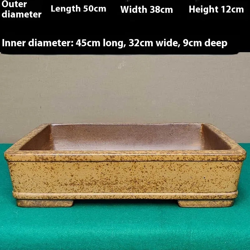 Straight-sided shallow rectangular flowerpot made from natural, unglazed purple sand clay, shown empty on a wooden surface.