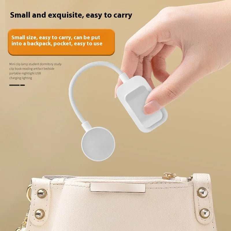 White plastic rechargeable LED book clip light clipped onto a book with USB charging cable