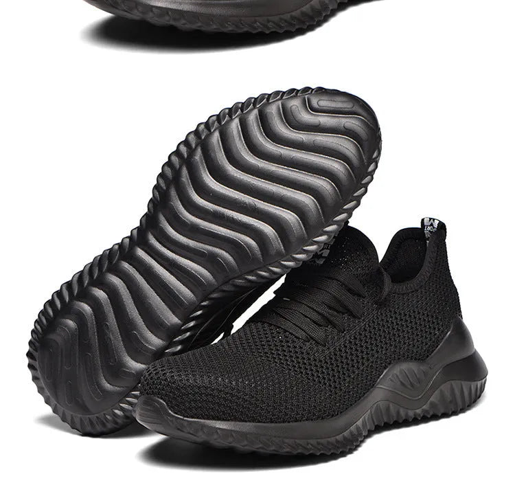 Black low-cut safety work shoe with a steel toe cap on a grey background.