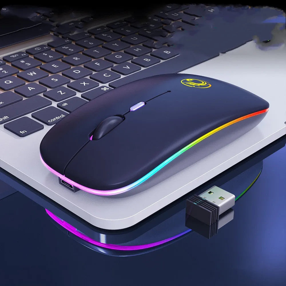 White dual-mode wireless mouse with silent buttons on a wooden desk next to a laptop.