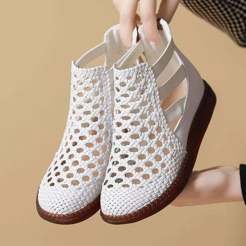 Gold flat sandals with round toe and breathable hollow-out design on a white background.