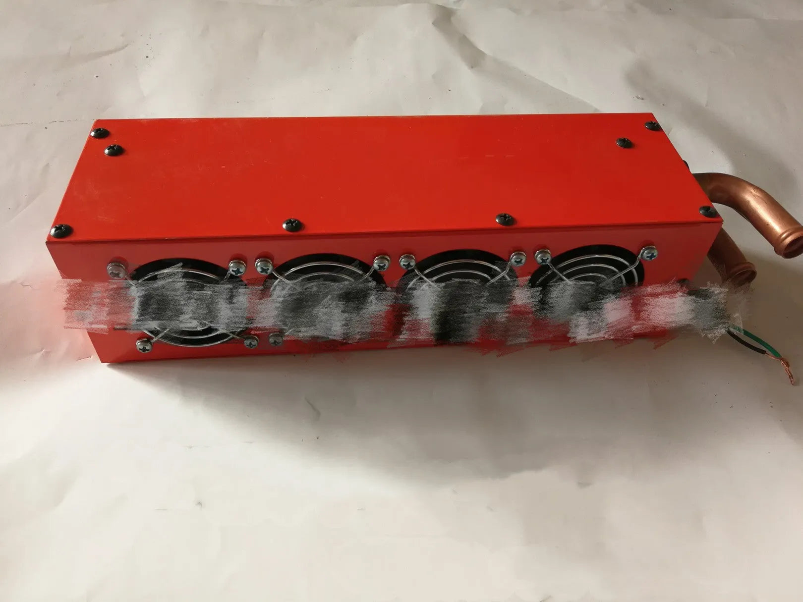 Long metal car heater unit with four copper pipe connectors for engine coolant.