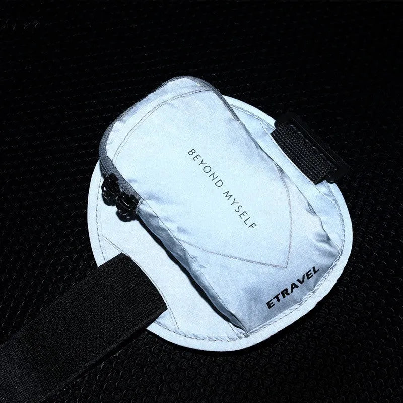 Black running arm bag with reflective strips, adjustable strap, and zip closure, shown on a person's arm.