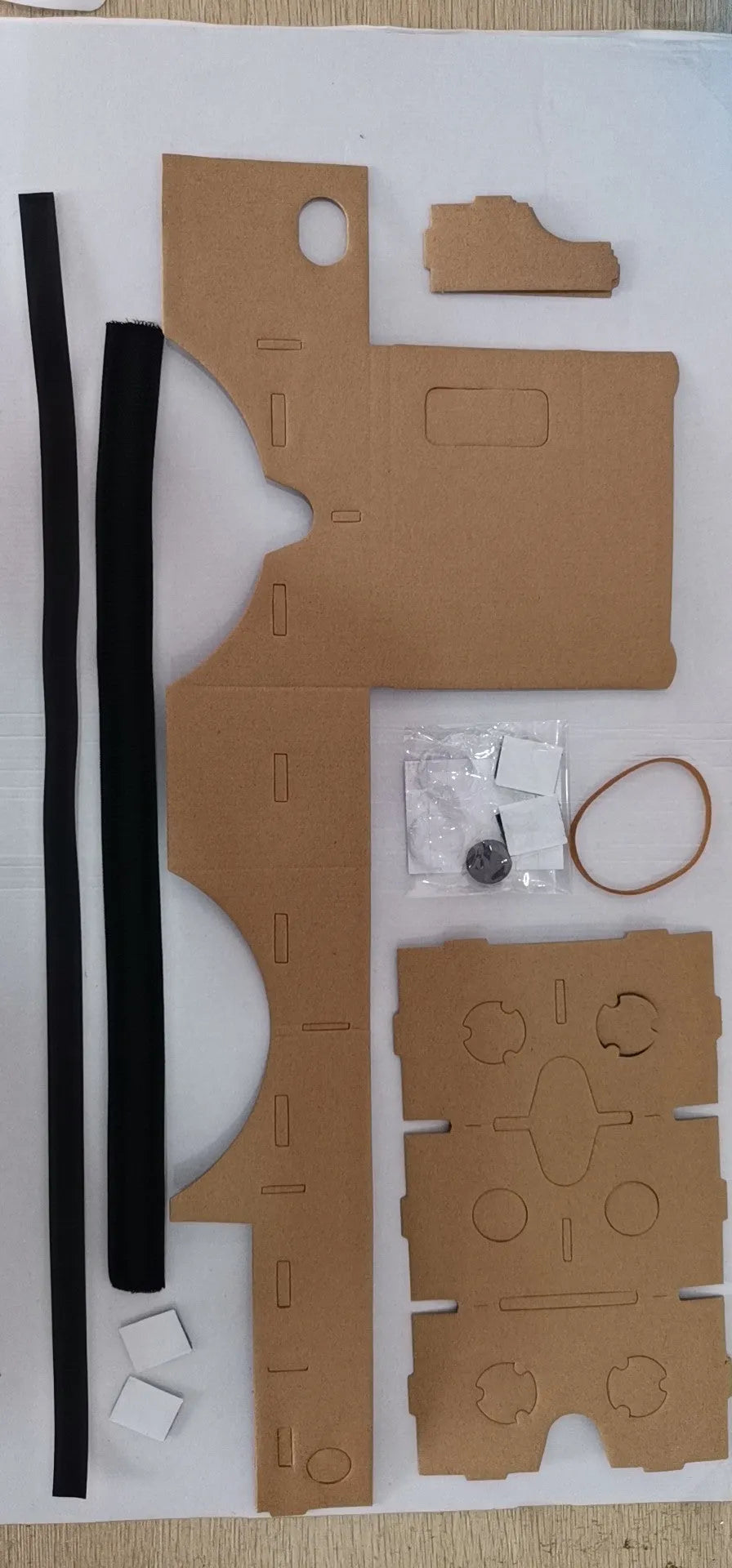 Pink and white cardboard VR glasses with adjustable rubber head strap and 3D lenses for smartphones.
