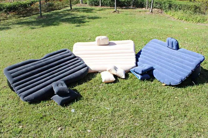 Inflatable car bed with flocked surface and two pillows, laid out in a vehicle.