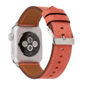Leather watch strap with a metal folding buckle on a wooden surface.