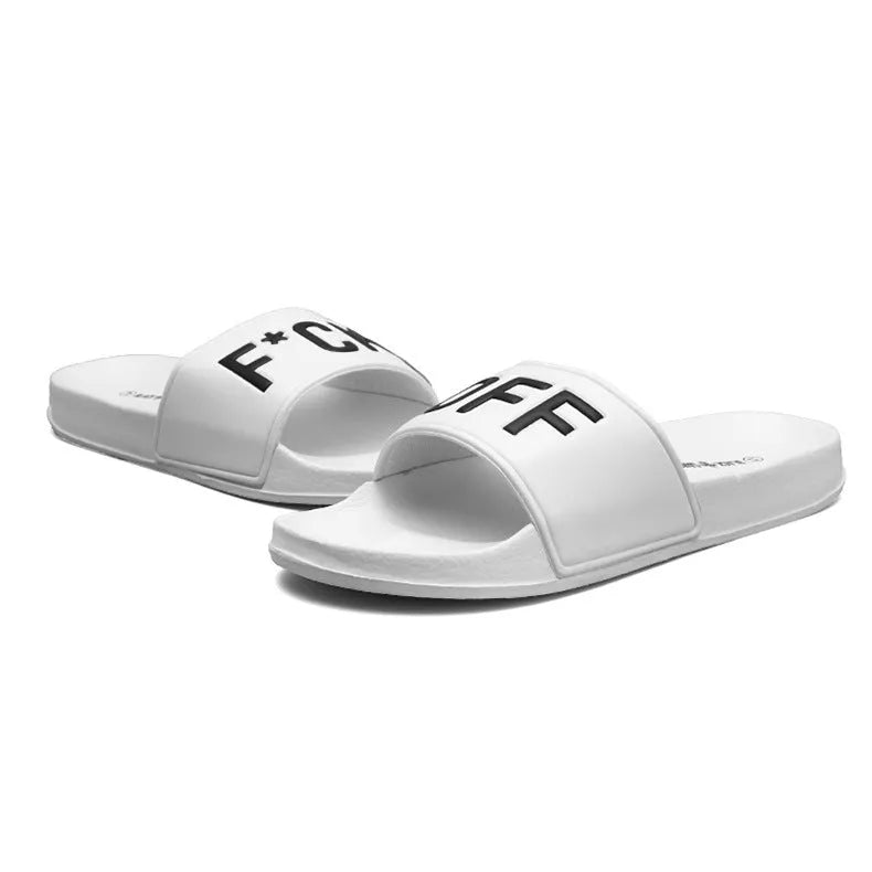 Men's black open-toe slipper with textured rubber sole, shown on a wooden floor.
