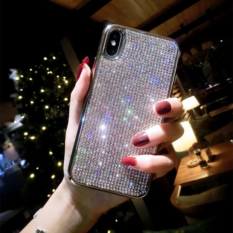 Silver full diamond glitter silicone protective case for iPhone on a table.