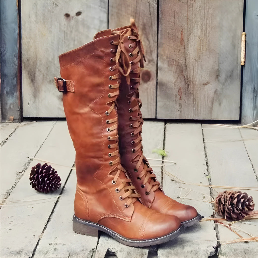 Black women's high-leg boot with a chunky low heel and round toe on a plain background.
