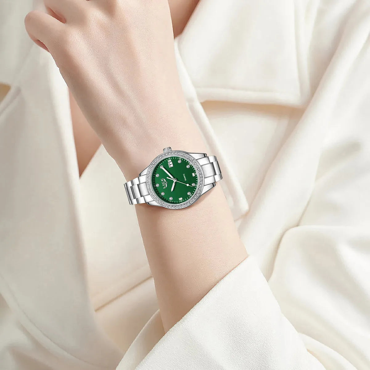 Silver stainless steel women's watch with diamond-encrusted bezel and luminous hands on a 34mm round dial.
