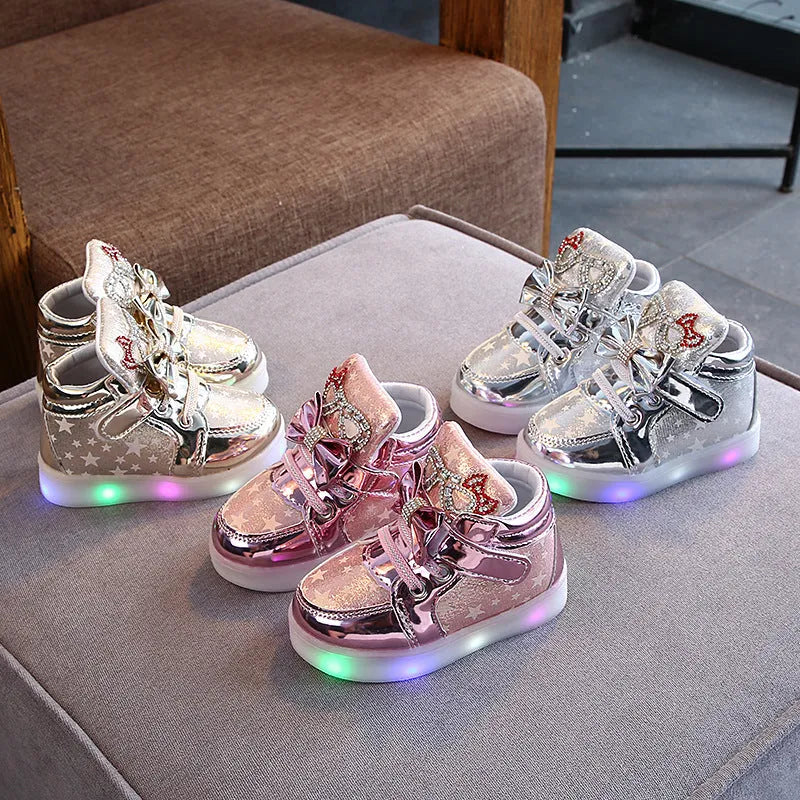 Children's LED magic button shoes with flashing lights in golden, pink, and silvery colours.