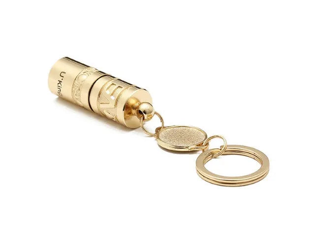 Gold-coloured zinc alloy mini LED flashlight on a keyring for outdoor and emergency use.
