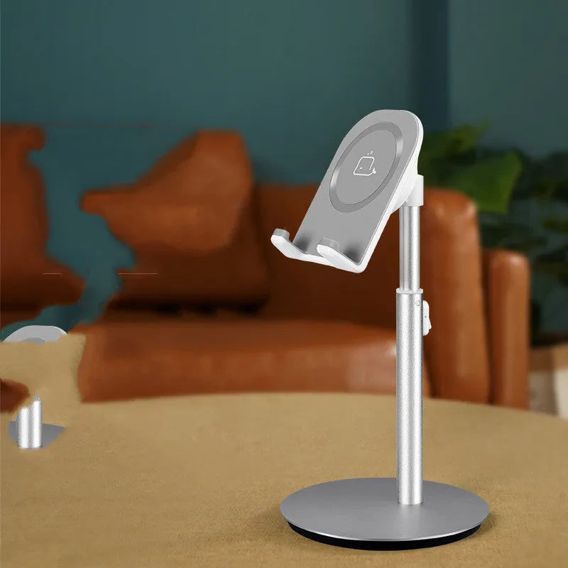Silver metal computer phone holder stand for smartphones and tablets on a desktop.