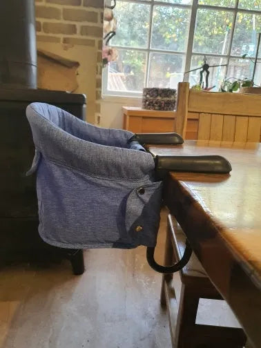 Portable baby high chair seat cover with safety belt in blue colour expanded on dining chair