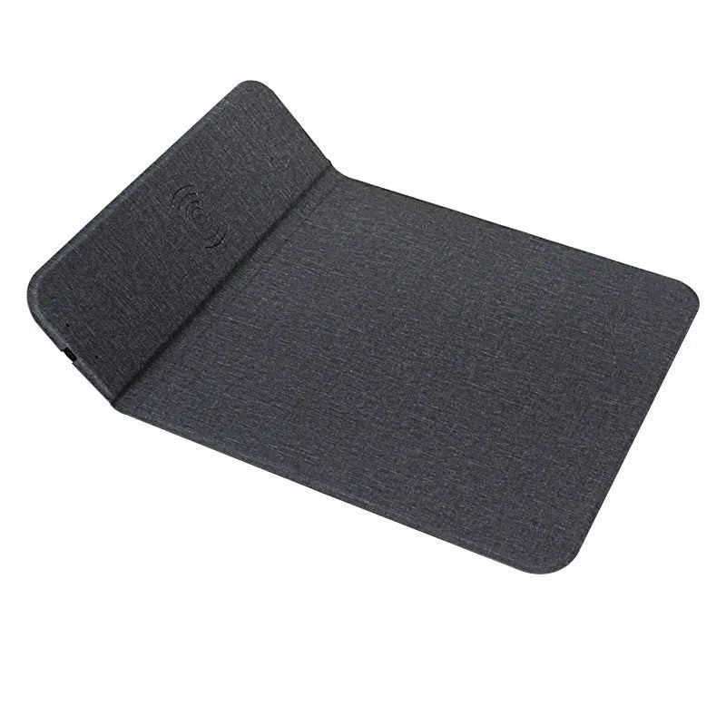 Grey foldable fabric phone holder with smartphone charging wirelessly on a wooden desk