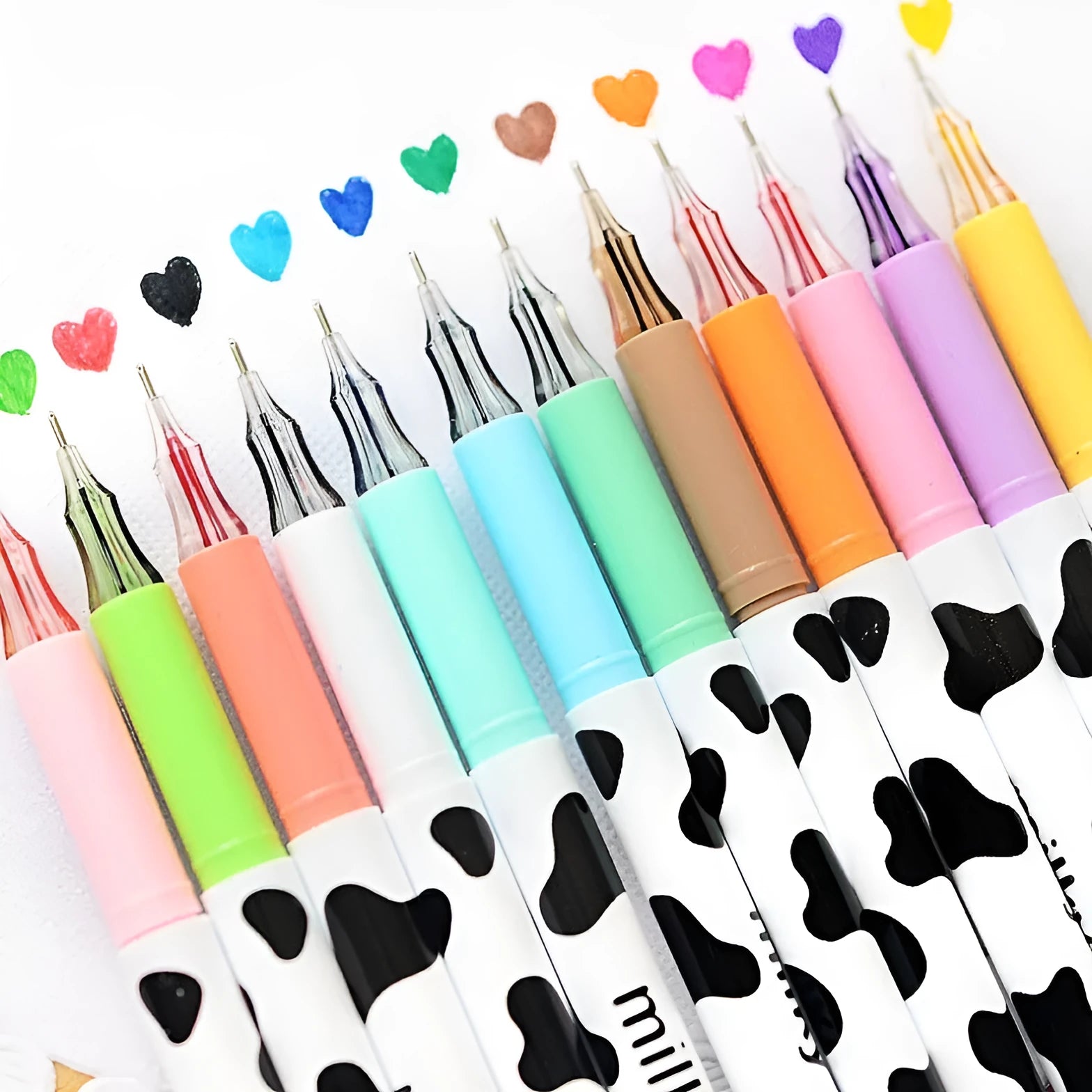 Box of 12 cow print coloured gel pens with 0.38mm fine tips on a desk.