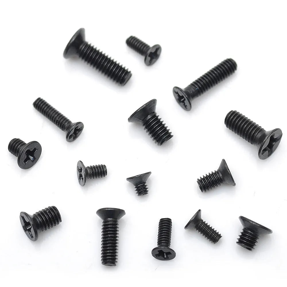 Black flat head M1.4 x 16mm laptop screws spilt from a box, showing cross slot drive and countersunk head profile.