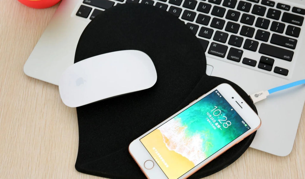Heart shaped red leather wireless charging mouse pad with indicator light on a desk