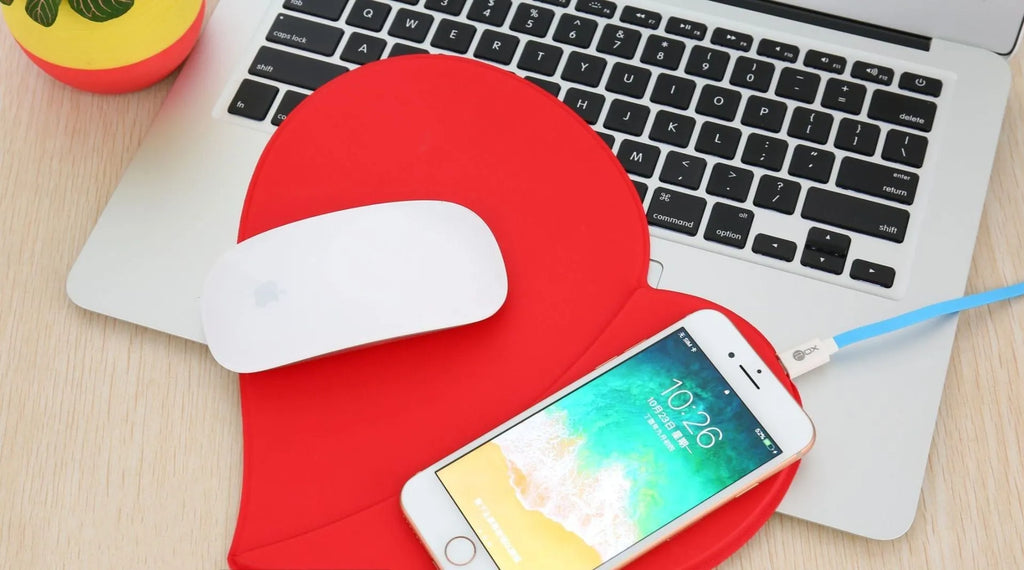 Heart shaped red leather wireless charging mouse pad with indicator light on a desk
