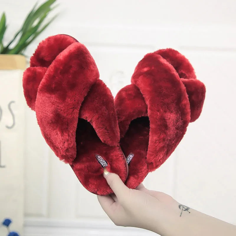 Women's black cross open-toe fur slippers on a white background, showing criss-cross upper and patterned sole.