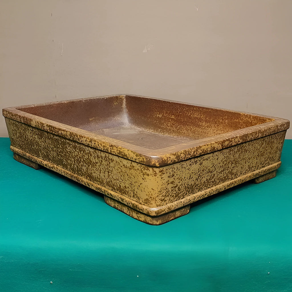 Straight-sided shallow rectangular flowerpot made from natural, unglazed purple sand clay, shown empty on a wooden surface.