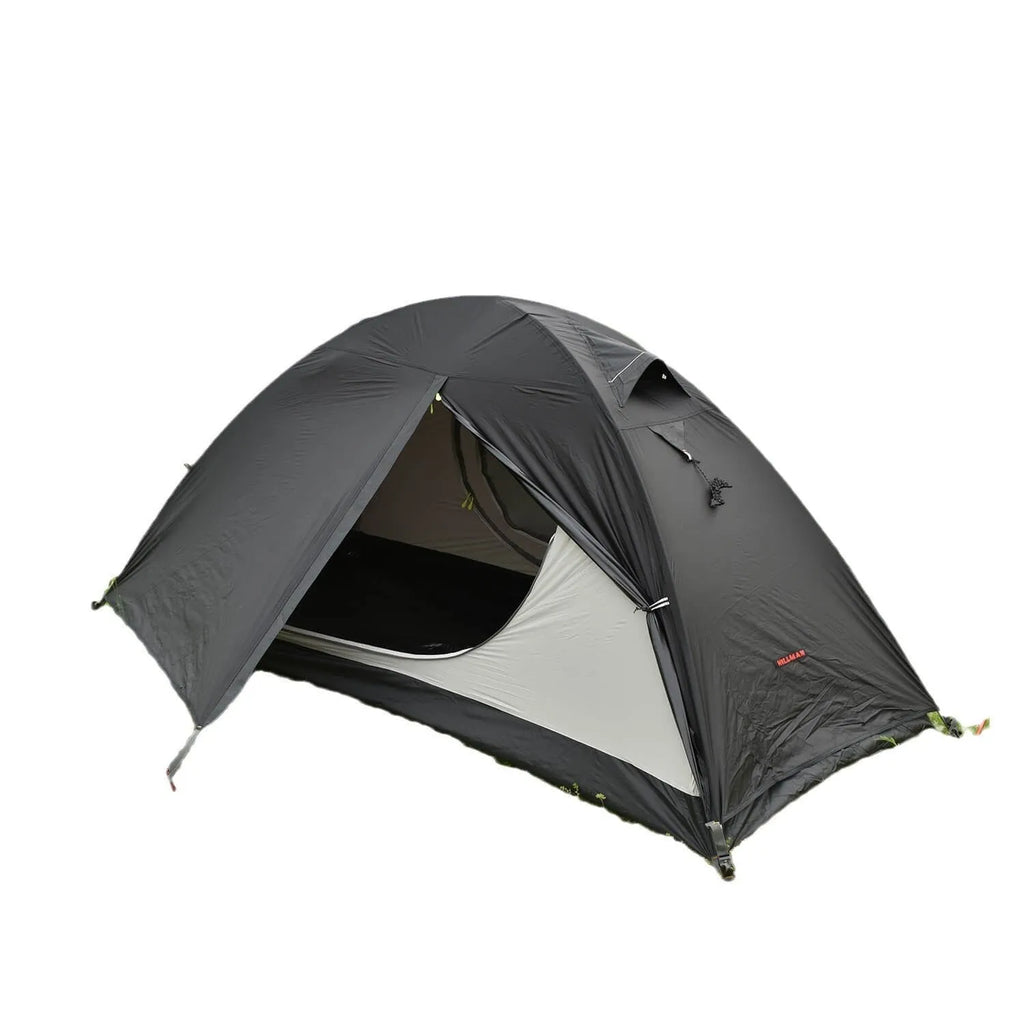 Single person orange double-layer hiking tent pitched in a field with aluminium poles visible.
