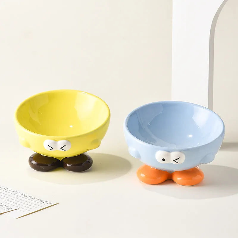 Blue ceramic pet bowl with tall, angled sides and a cute face design for cat or small dog feeding.