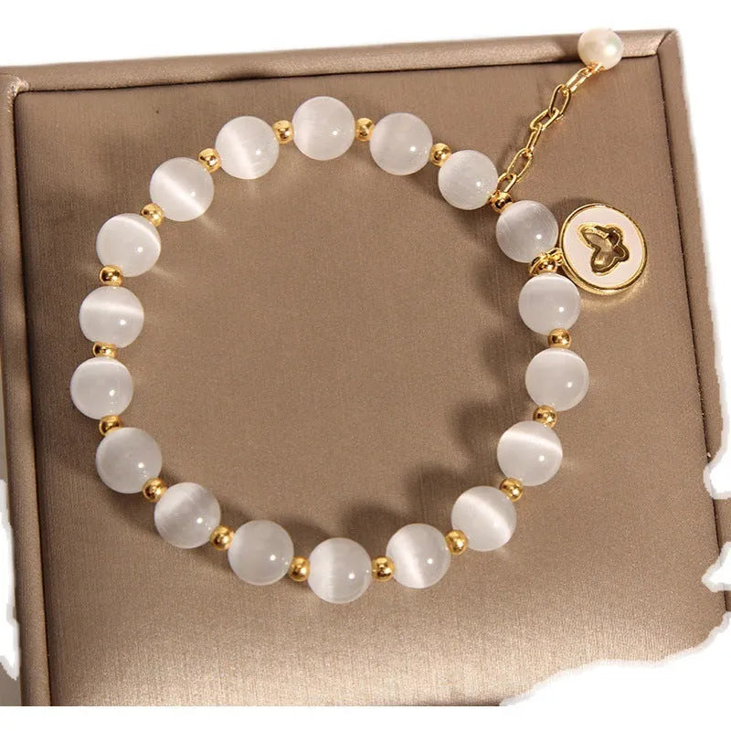 White geometric Cat's Eye crystal bracelet on a wrist, showing its handcrafted Korean-style design.