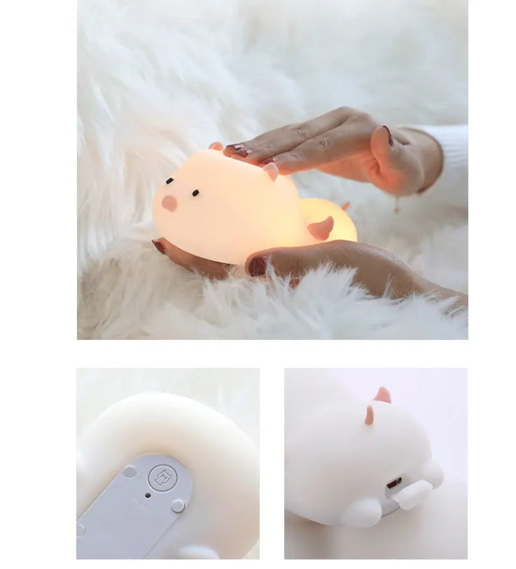 Pink silicone night light in the shape of a sleeping pig on a table.