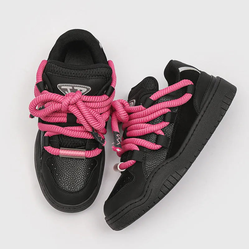 Pair of low-top unisex casual sneakers with thick flat rubber sole and lace-up front in a solid colour.