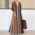 Camel coloured women's long dress with vertical stripes, V-neck, and long sleeves on a hanger.