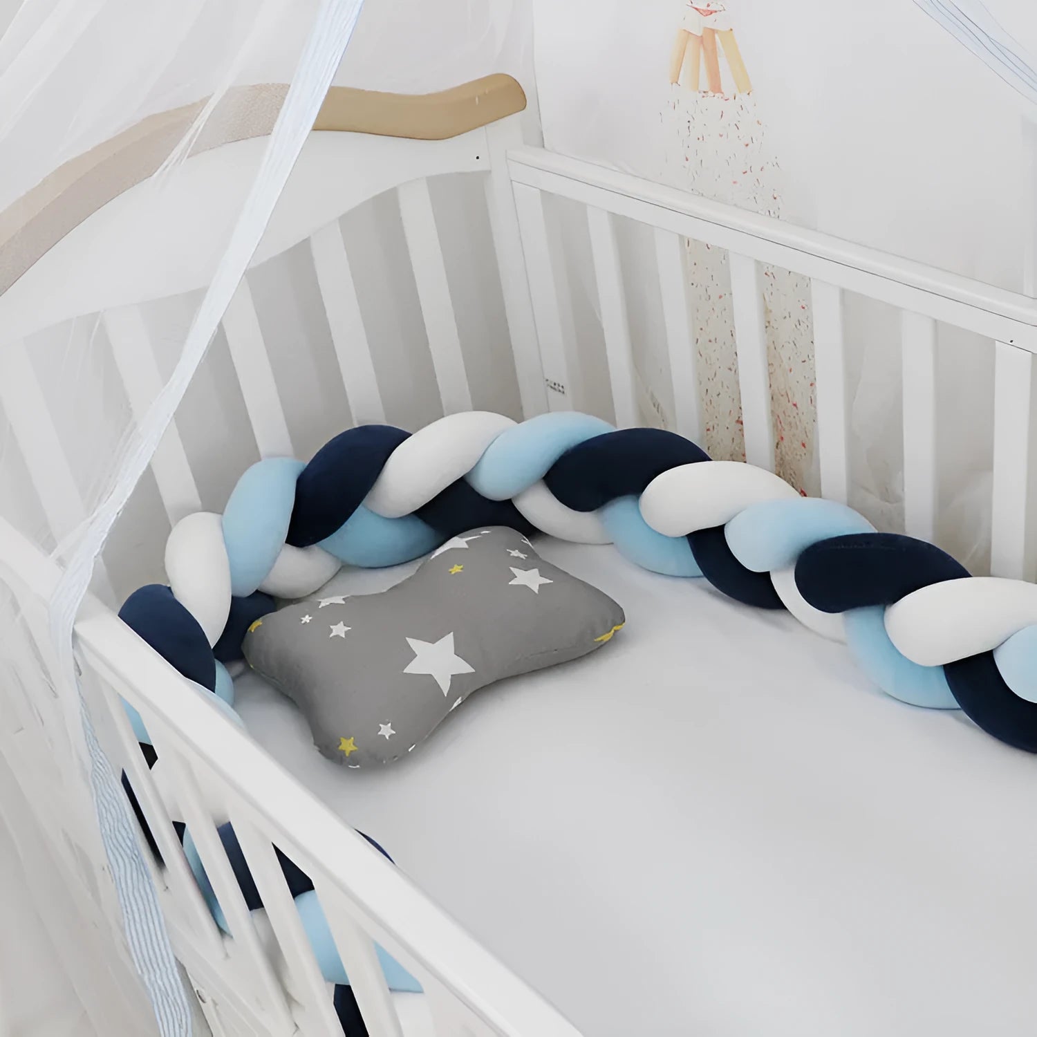 Braided knot style crib bumper in spandex velvet, wrapped around white cot rails in a nursery.