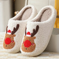 Christmas winter home slippers in red with plush upper and anti-slip sole on a wooden floor