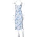 Women's long blue lace print dress with a high side slit and thin black suspender straps.